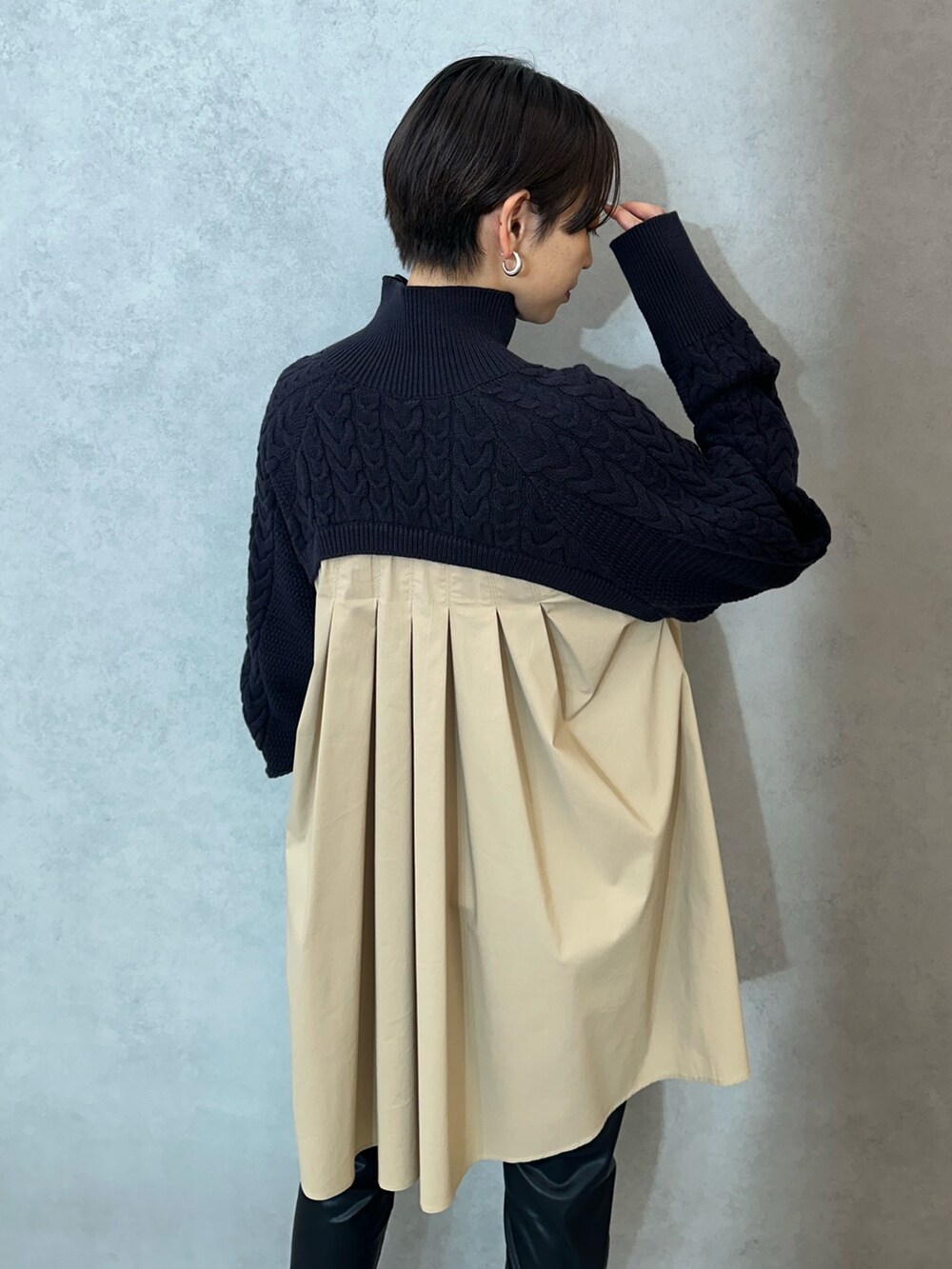 ブルー系のニット/セーター、ブラック系のその他パンツ、ブラック系のブーツを着用したレディースの秋コーディネートの6枚目の写真