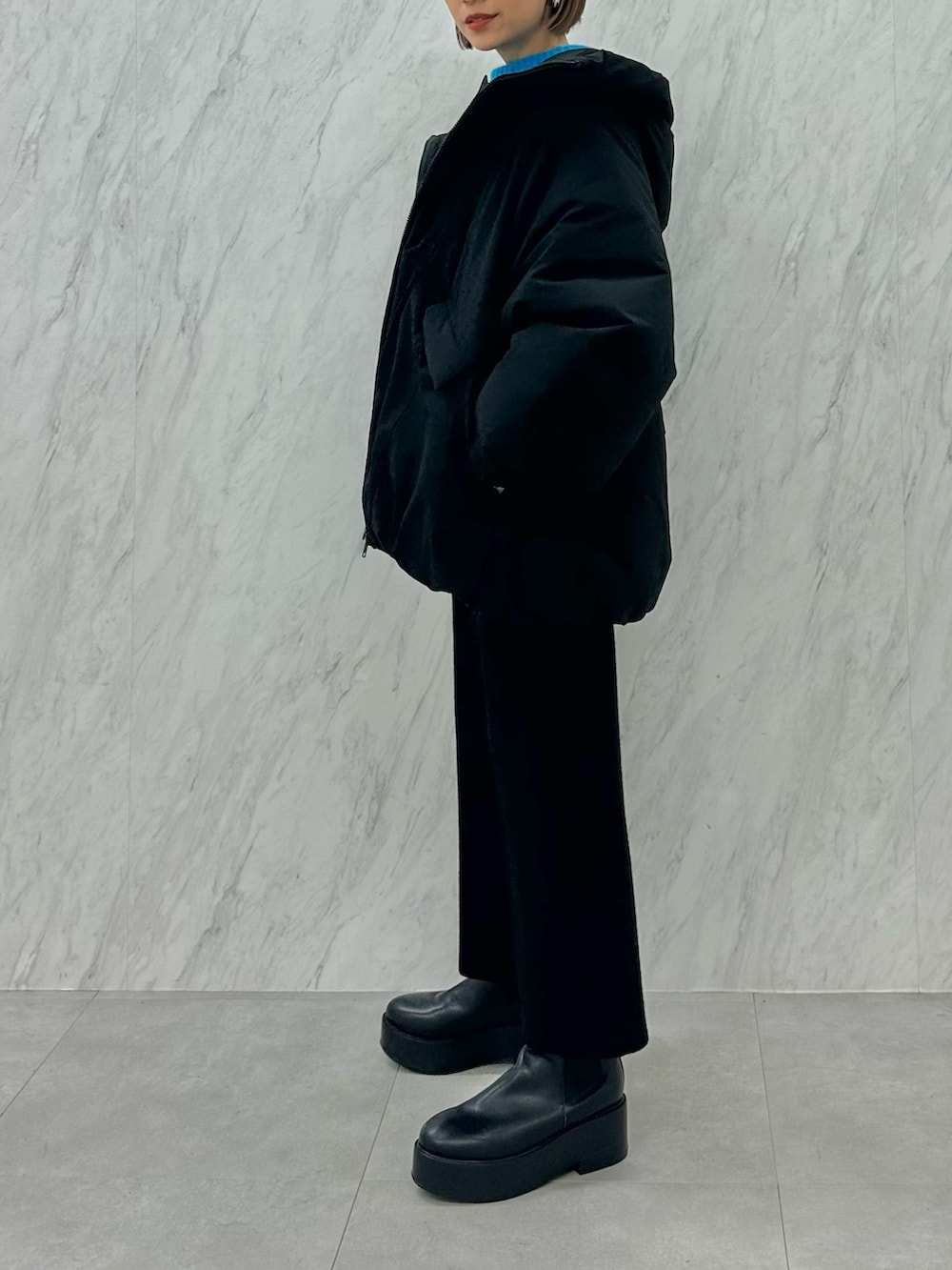 ブラック系のブーツ、ブラック系のスカート、ブラック系のダウンジャケット/コートを着用したレディースの秋コーディネートの2枚目の写真