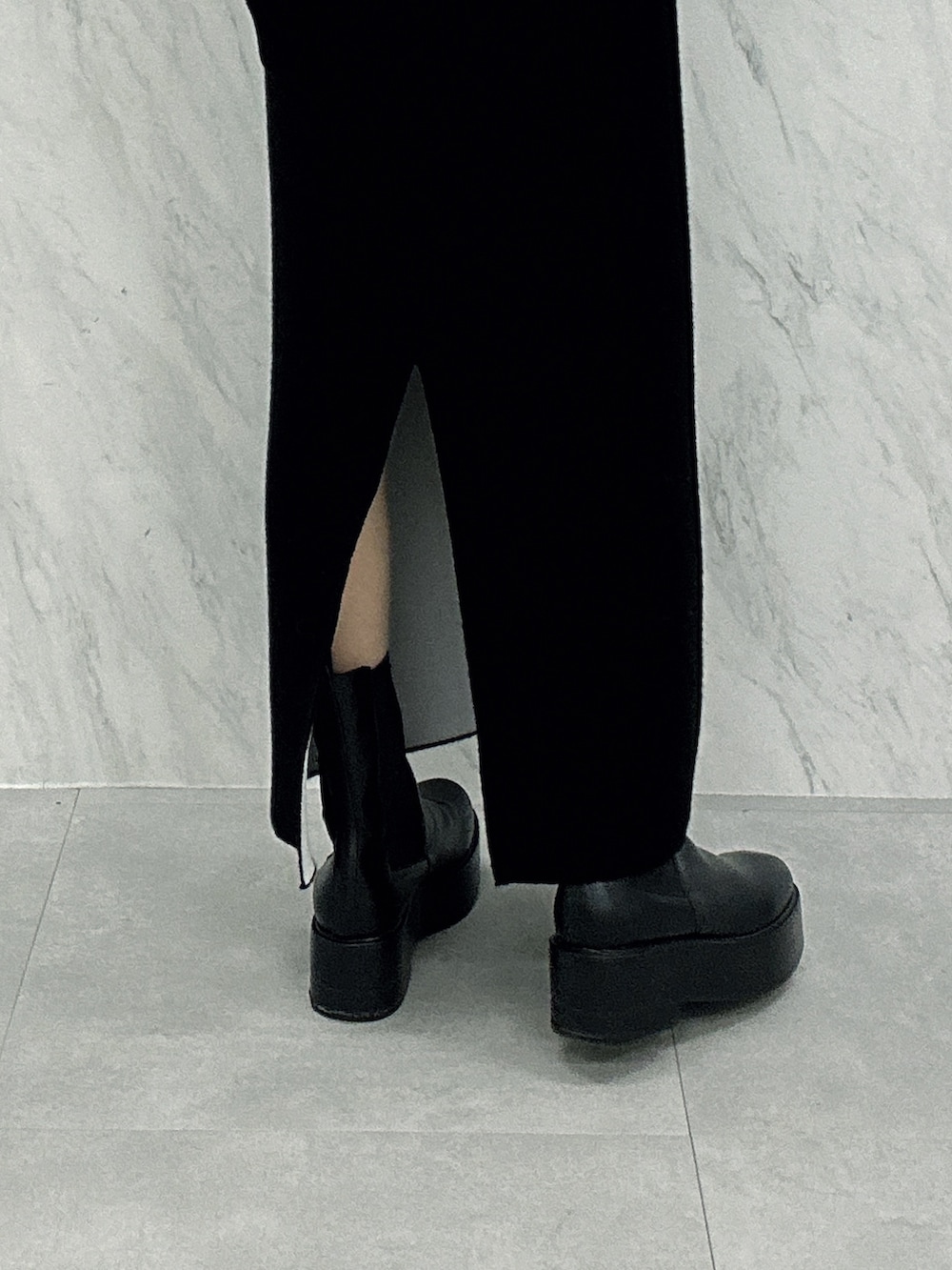 ブラック系のブーツ、ブラック系のスカート、ブラック系のダウンジャケット/コートを着用したレディースの秋コーディネートの9枚目の写真