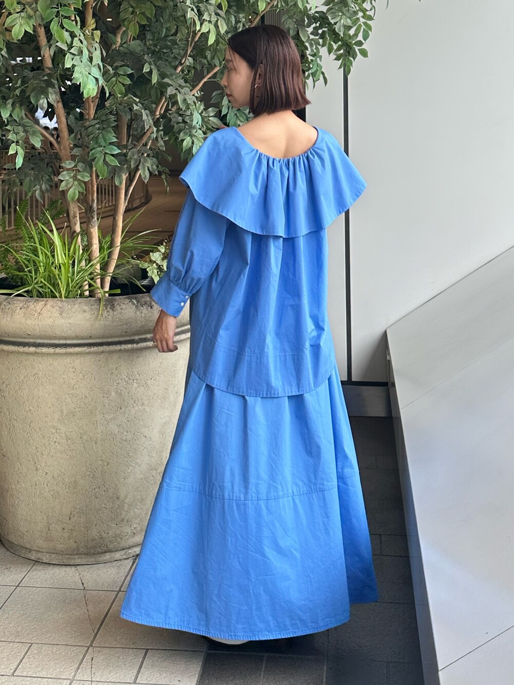 ブルー系のシャツ/ブラウス、ブルー系のスカート、ホワイト系のパンプスを着用したレディースの夏コーディネートの9枚目の写真