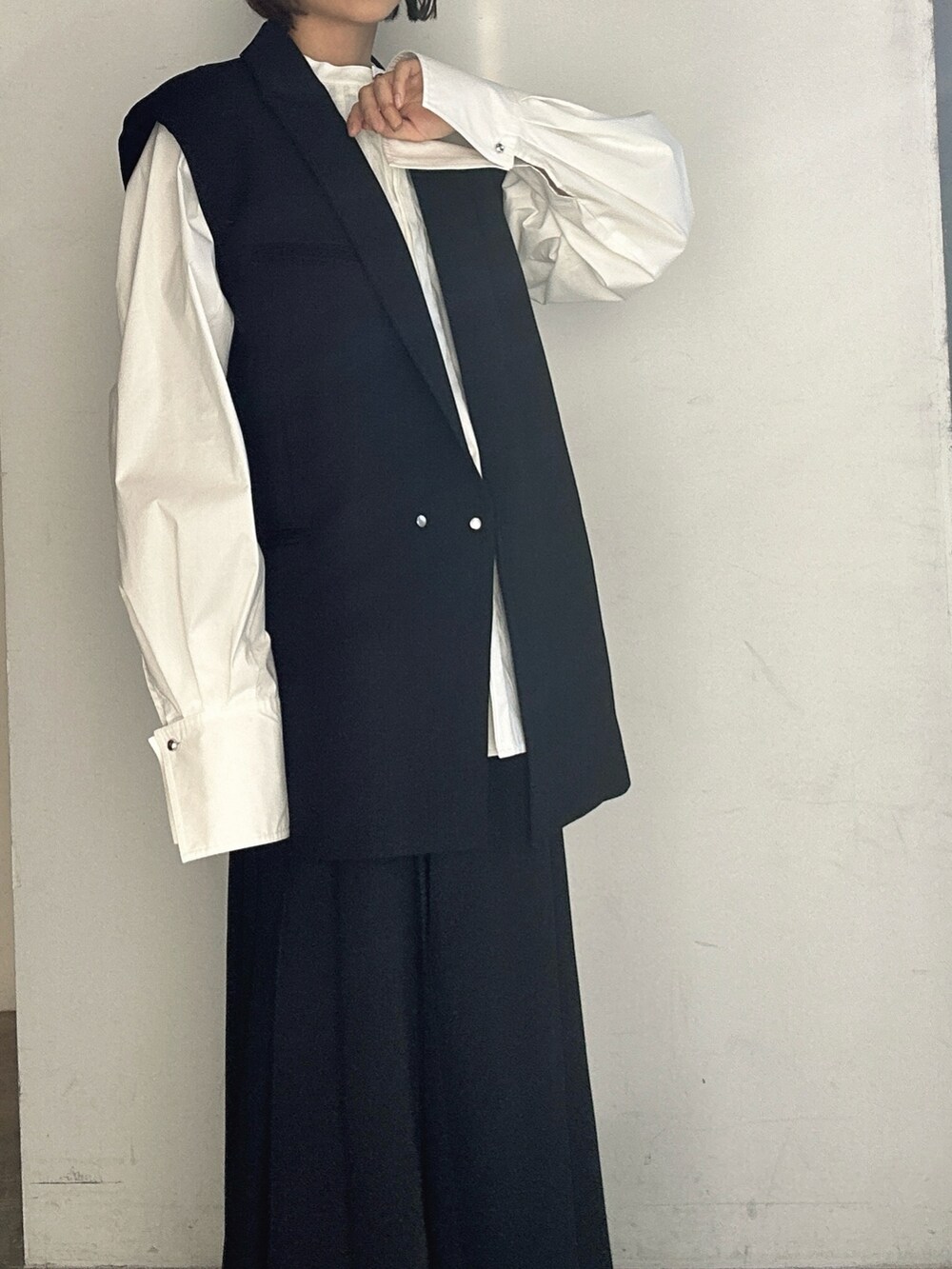 シルバー系のパンプス、ブラック系のテーラードジャケット、ブラック系のスカートを着用したレディースの冬コーディネートの7枚目の写真