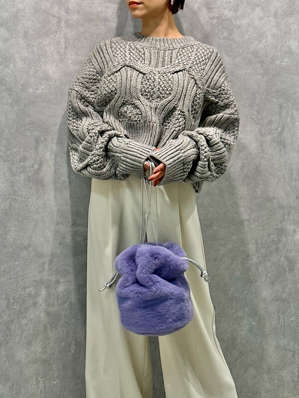 グレー系のニット/セーター、ホワイト系のその他パンツ、ブラック系のブーツを着用したレディースの秋コーディネートの4枚目の写真