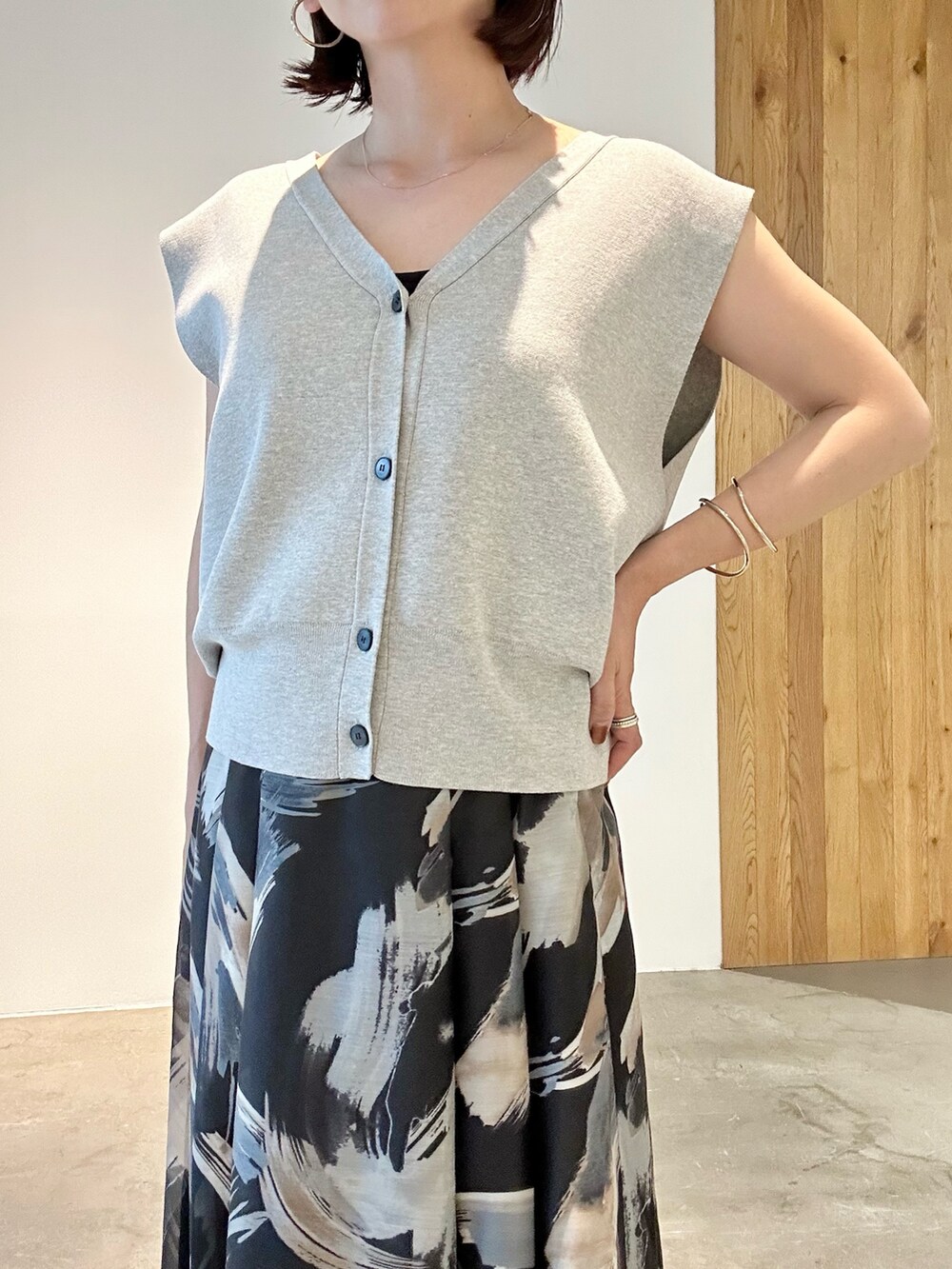 ブラック系のスカート、ホワイト系のサンダル、グレー系のニット/セーターを着用したレディースの春コーディネートの7枚目の写真