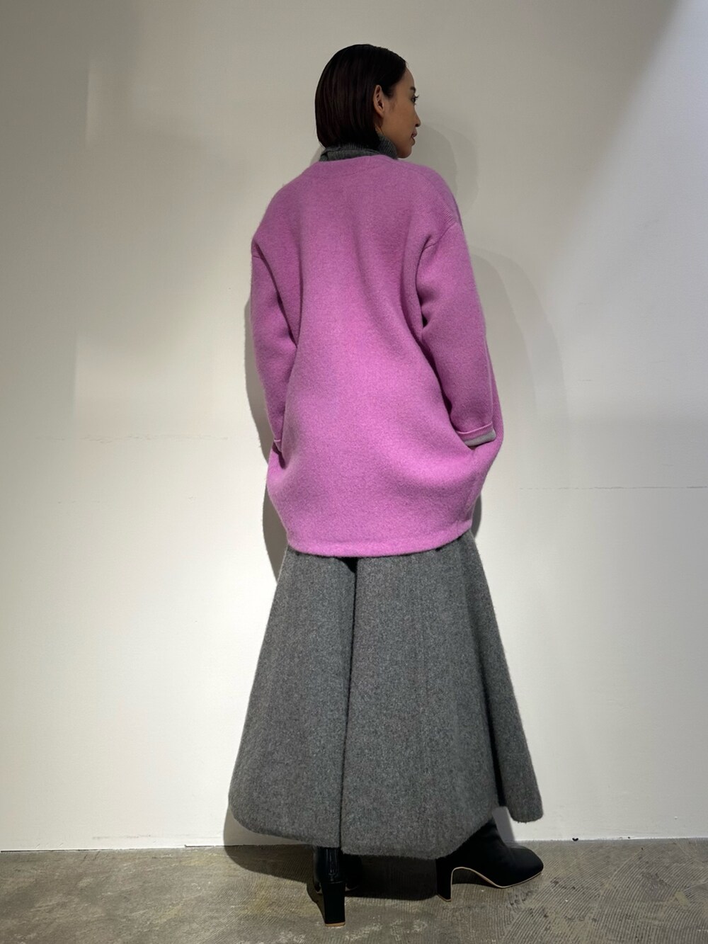 パープル系のノーカラージャケット、グレー系のスカート、ブラック系のブーツを着用したレディースの秋コーディネートの3枚目の写真