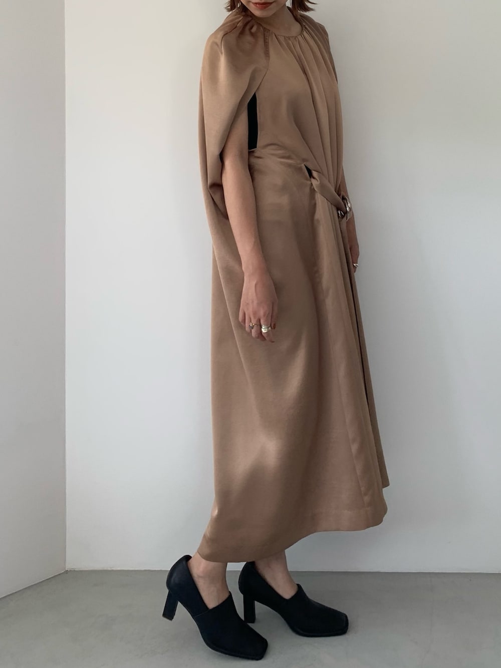 ブラック系のパンプス、ベージュ系のドレスを着用したレディースの春コーディネートの4枚目の写真