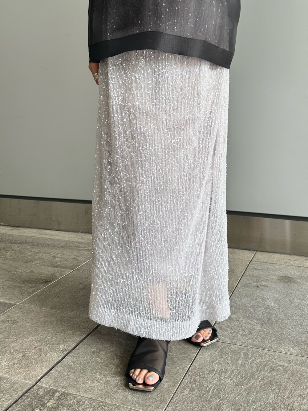 ブラック系のシャツ/ブラウス、シルバー系のスカートを着用したレディースの夏コーディネートの7枚目の写真