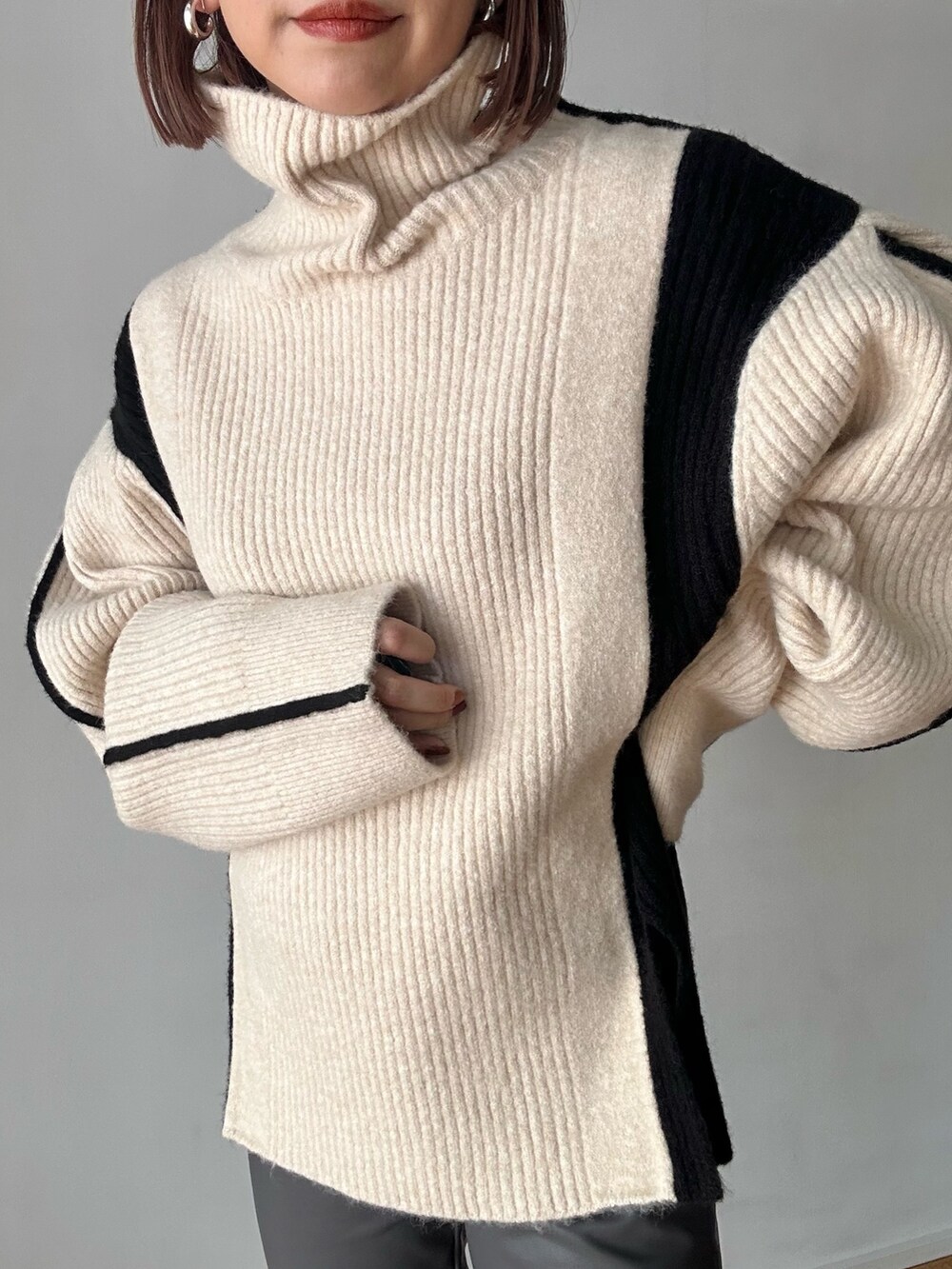 ホワイト系のニット/セーター、グレー系のその他パンツ、ブラック系のブーツを着用したレディースの秋コーディネートの8枚目の写真