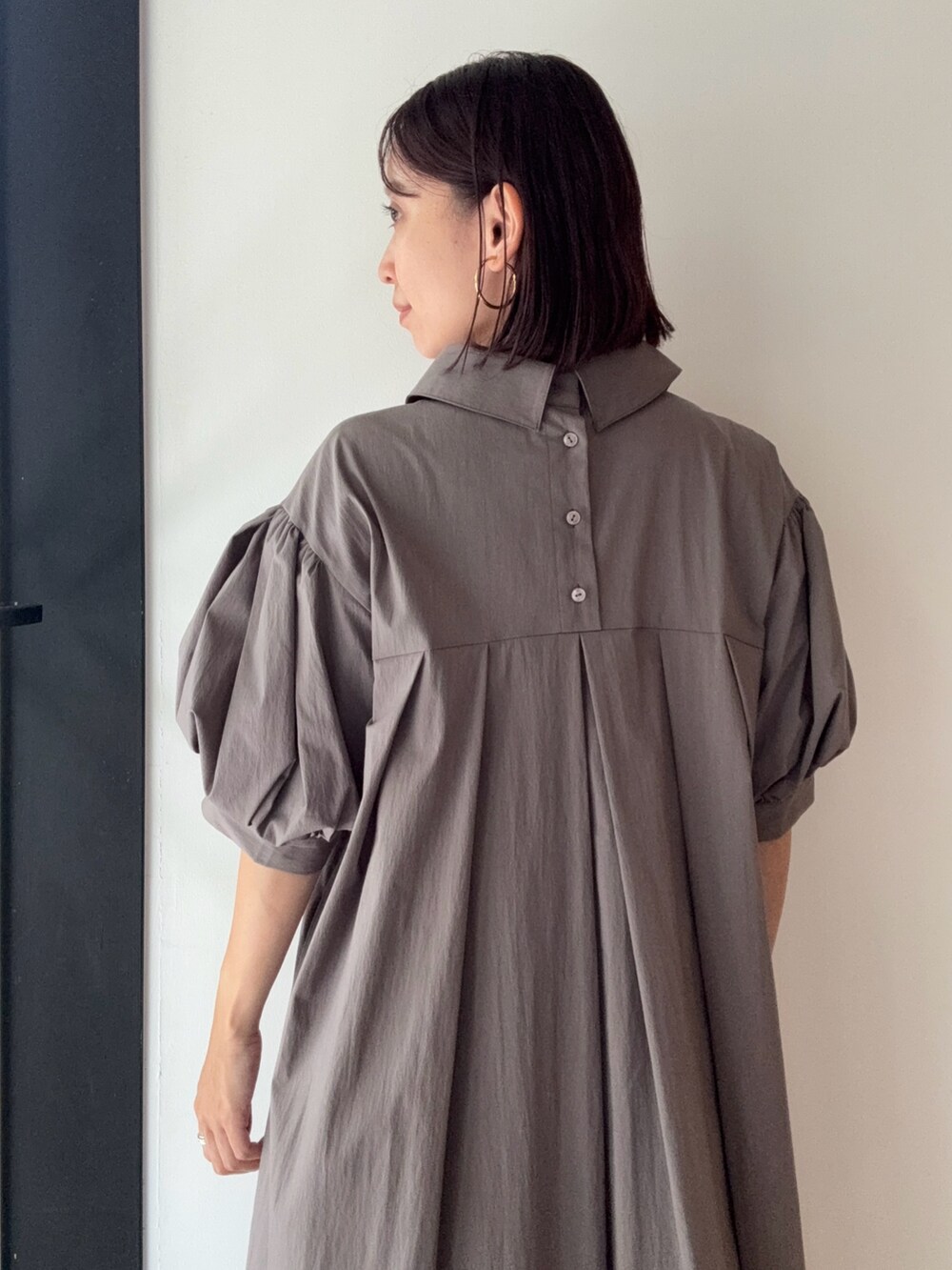 グレー系のワンピース、シルバー系のパンプス、レッド系のショルダーバッグを着用したレディースの夏コーディネートの6枚目の写真