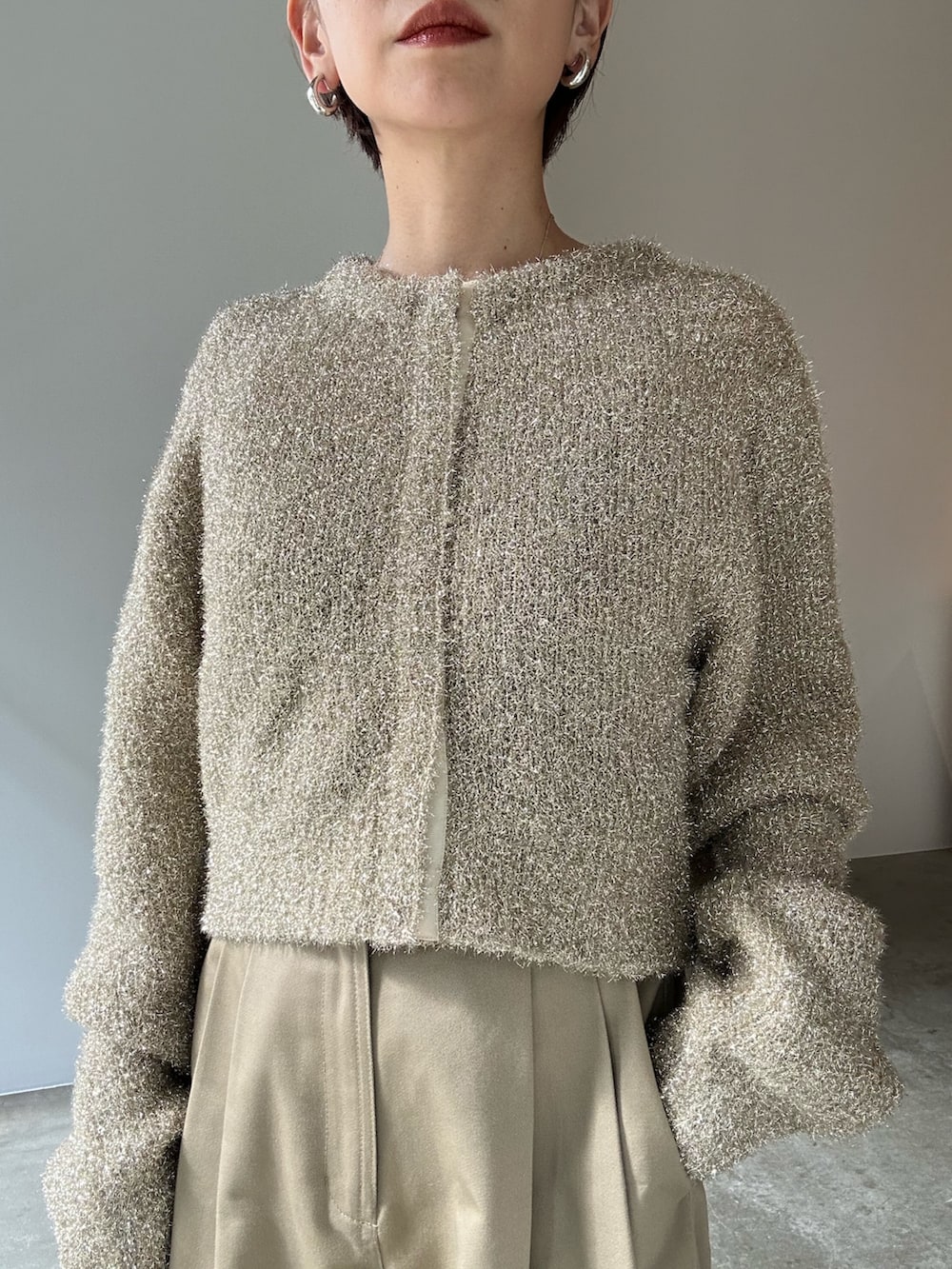 ゴールド系のカーディガン/ボレロ、ベージュ系のその他パンツ、ブラック系のサンダルを着用したレディースの冬コーディネートの7枚目の写真