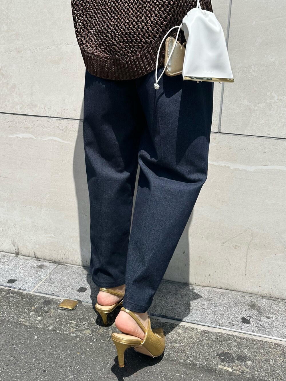 ブラウン系のニット/セーター、ブルー系のつなぎ/オールインワン、ゴールド系のサンダルを着用したレディースの春コーディネートの8枚目の写真