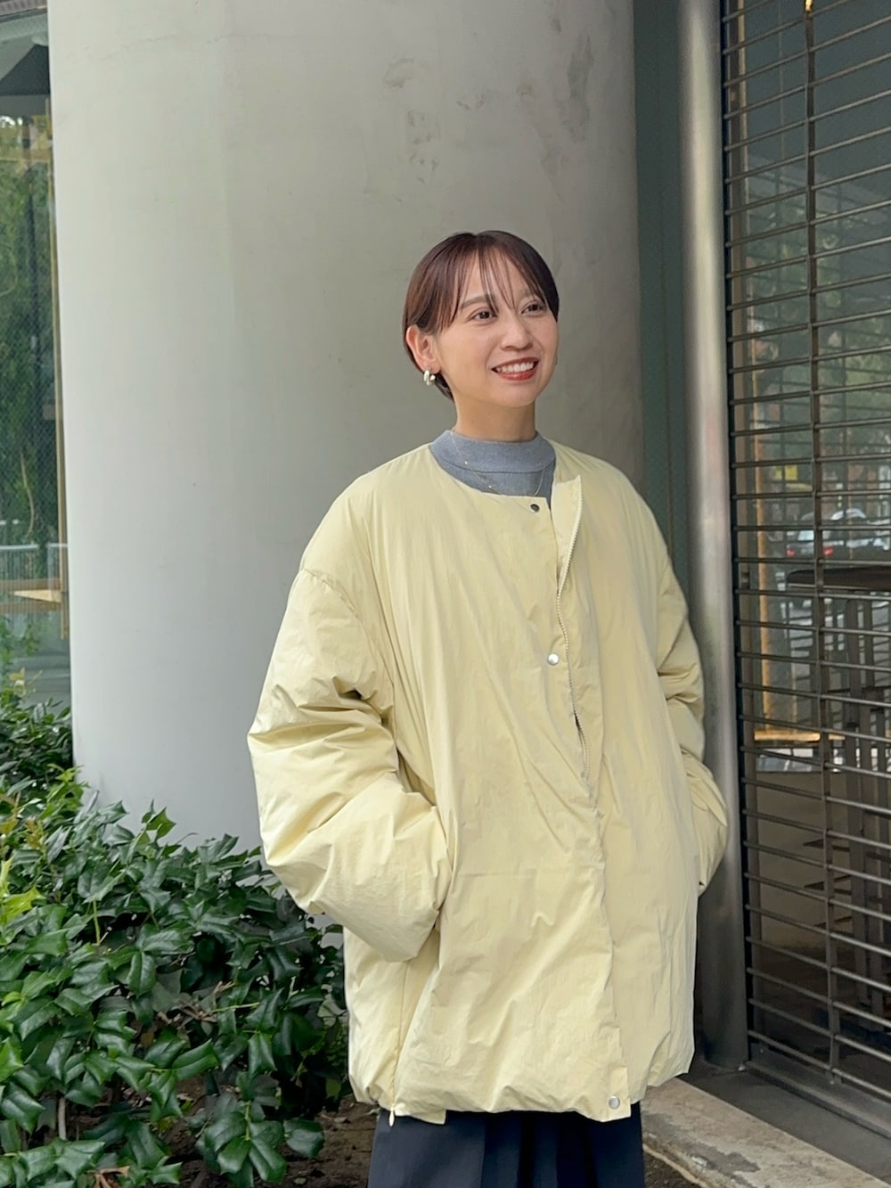 イエロー系のダウンジャケット/コート、グレー系のワンピース、ブラック系のブーツを着用したレディースの夏コーディネートの8枚目の写真