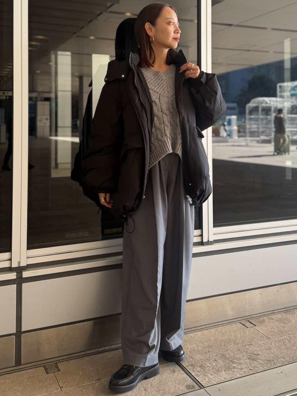 グレー系のニット/セーター、グレー系のその他パンツ、ブラック系のローファーを着用したレディースの冬コーディネートの2枚目の写真