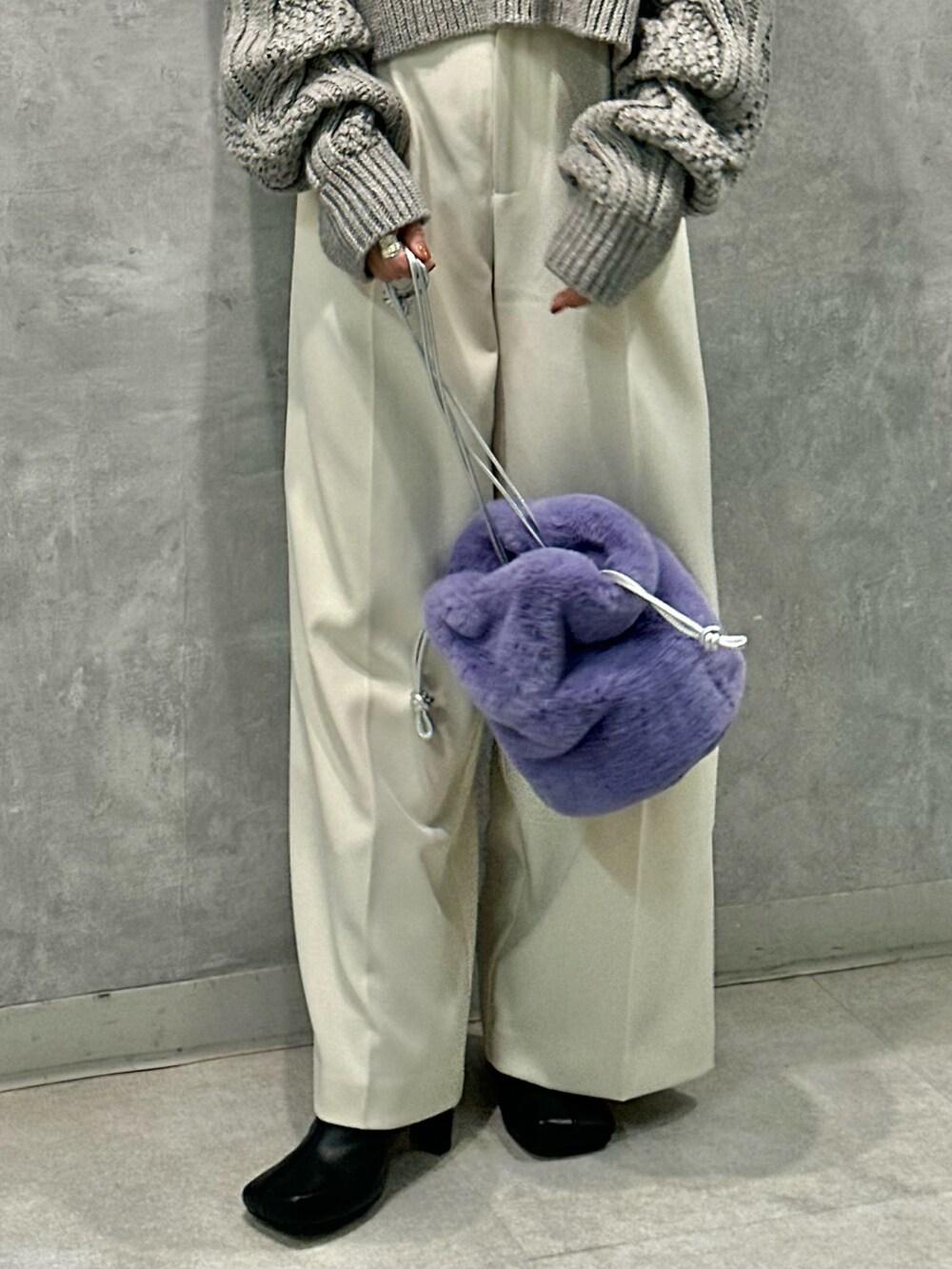 グレー系のニット/セーター、ホワイト系のその他パンツ、ブラック系のブーツを着用したレディースの秋コーディネートの8枚目の写真