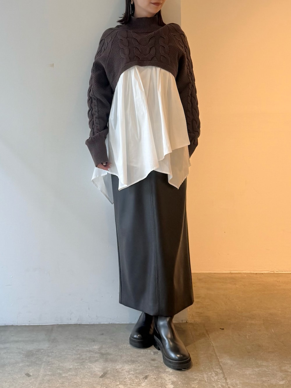 ブラック系のスカート、ブラウン系のニット/セーターを着用したレディースの秋コーディネートの2枚目の写真
