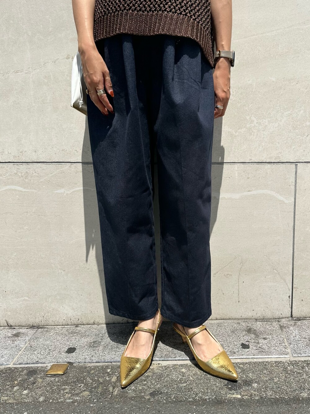 ブラウン系のニット/セーター、ブルー系のつなぎ/オールインワン、ゴールド系のサンダルを着用したレディースの春コーディネートの6枚目の写真