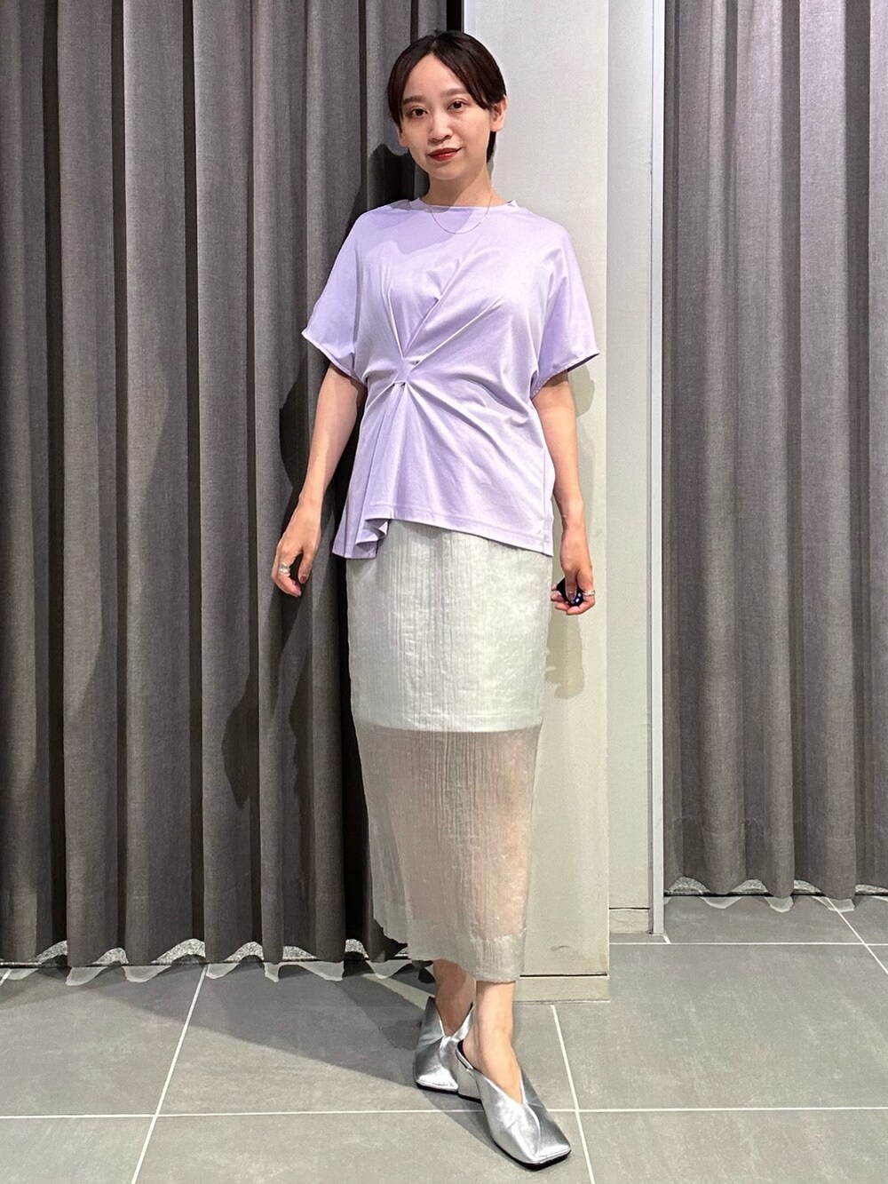 パープル系のTシャツ/カットソー、グレー系のスカート、シルバー系のパンプスを着用したレディースの夏コーディネートの2枚目の写真