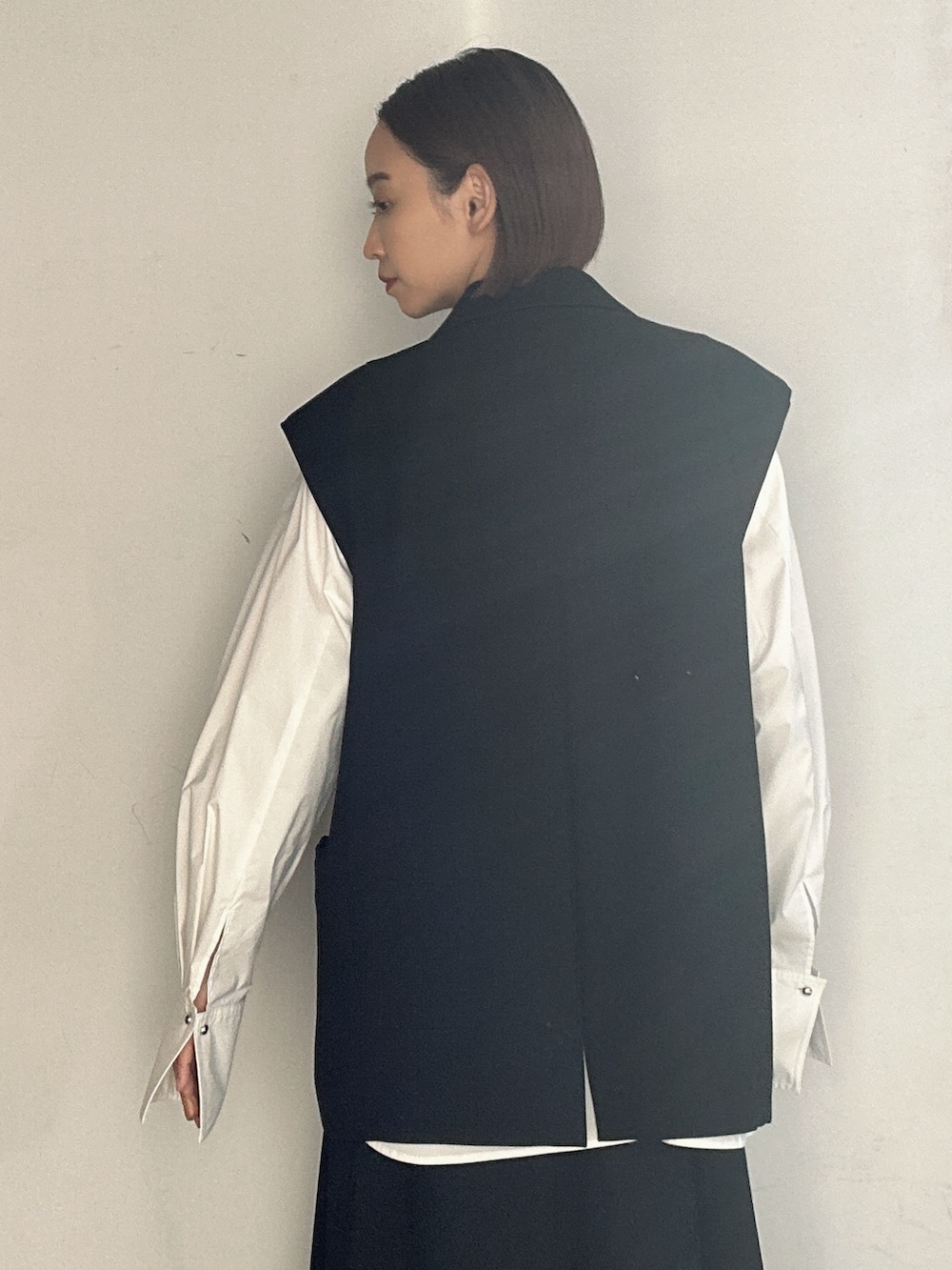 シルバー系のパンプス、ブラック系のテーラードジャケット、ブラック系のスカートを着用したレディースの冬コーディネートの8枚目の写真