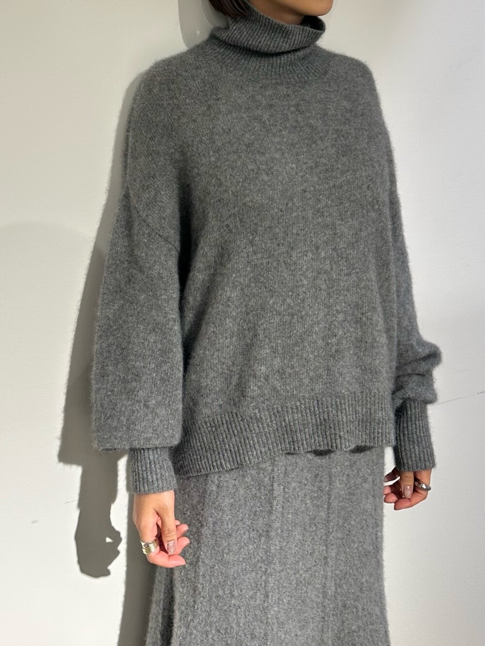 パープル系のノーカラージャケット、グレー系のスカート、ブラック系のブーツを着用したレディースの秋コーディネートの7枚目の写真