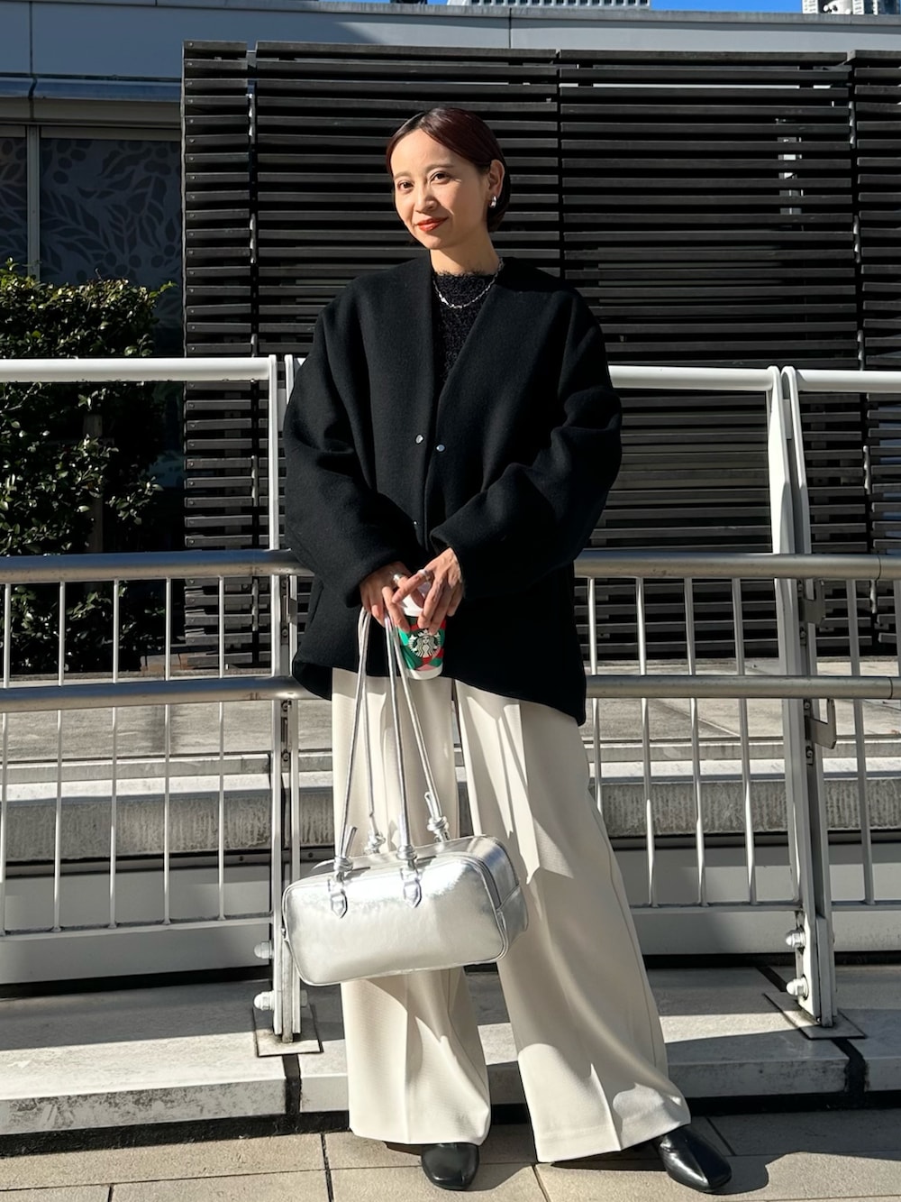 ブラック系のノーカラージャケット、シルバー系のボストンバッグ、ホワイト系のその他パンツを着用したレディースの冬コーディネートの2枚目の写真