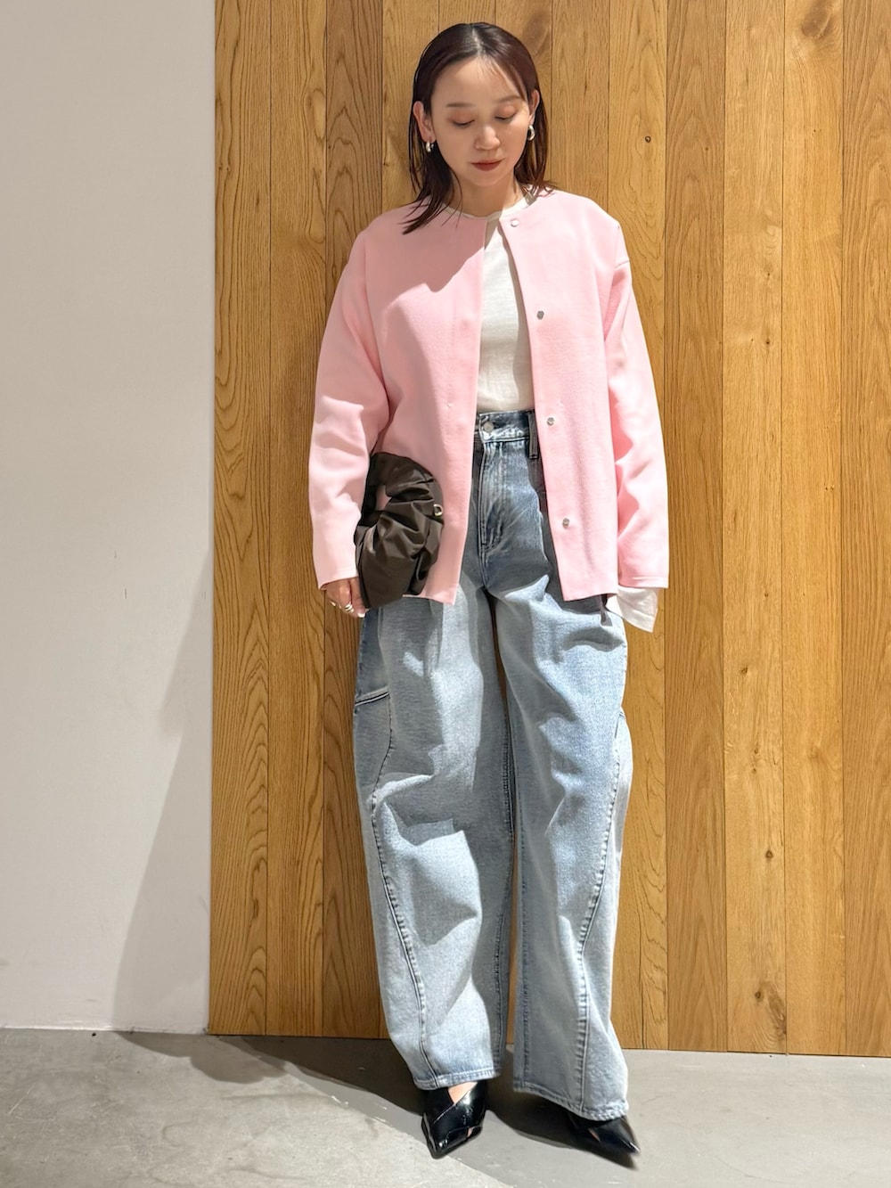 ブルー系のデニムパンツ、ブラック系のパンプス、ピンク系のカーディガン/ボレロを着用したレディースの冬コーディネートの2枚目の写真