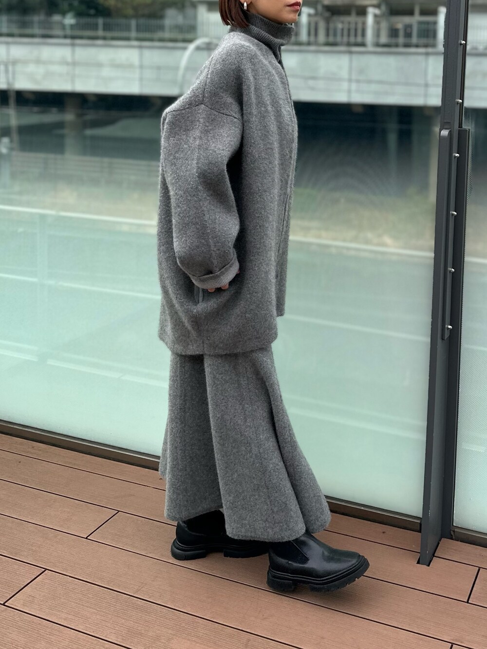 グレー系のスカート、グレー系のノーカラージャケット、グレー系のニット/セーターを着用したレディースの冬コーディネートの4枚目の写真