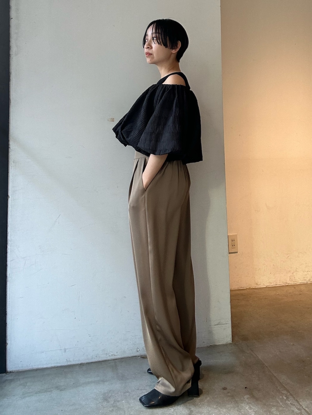 ブラック系のシャツ/ブラウス、ベージュ系のその他パンツ、ブラック系のパンプスを着用したレディースの春コーディネートの6枚目の写真