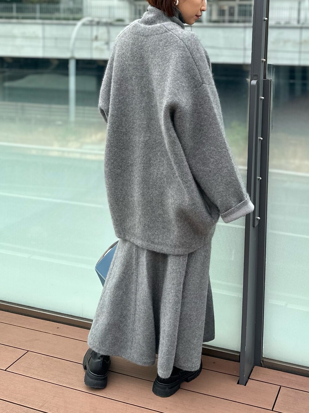グレー系のスカート、グレー系のノーカラージャケット、グレー系のニット/セーターを着用したレディースの冬コーディネートの5枚目の写真