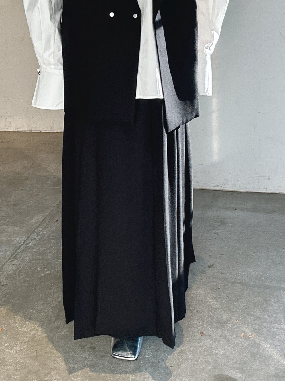 シルバー系のパンプス、ブラック系のテーラードジャケット、ブラック系のスカートを着用したレディースの冬コーディネートの9枚目の写真