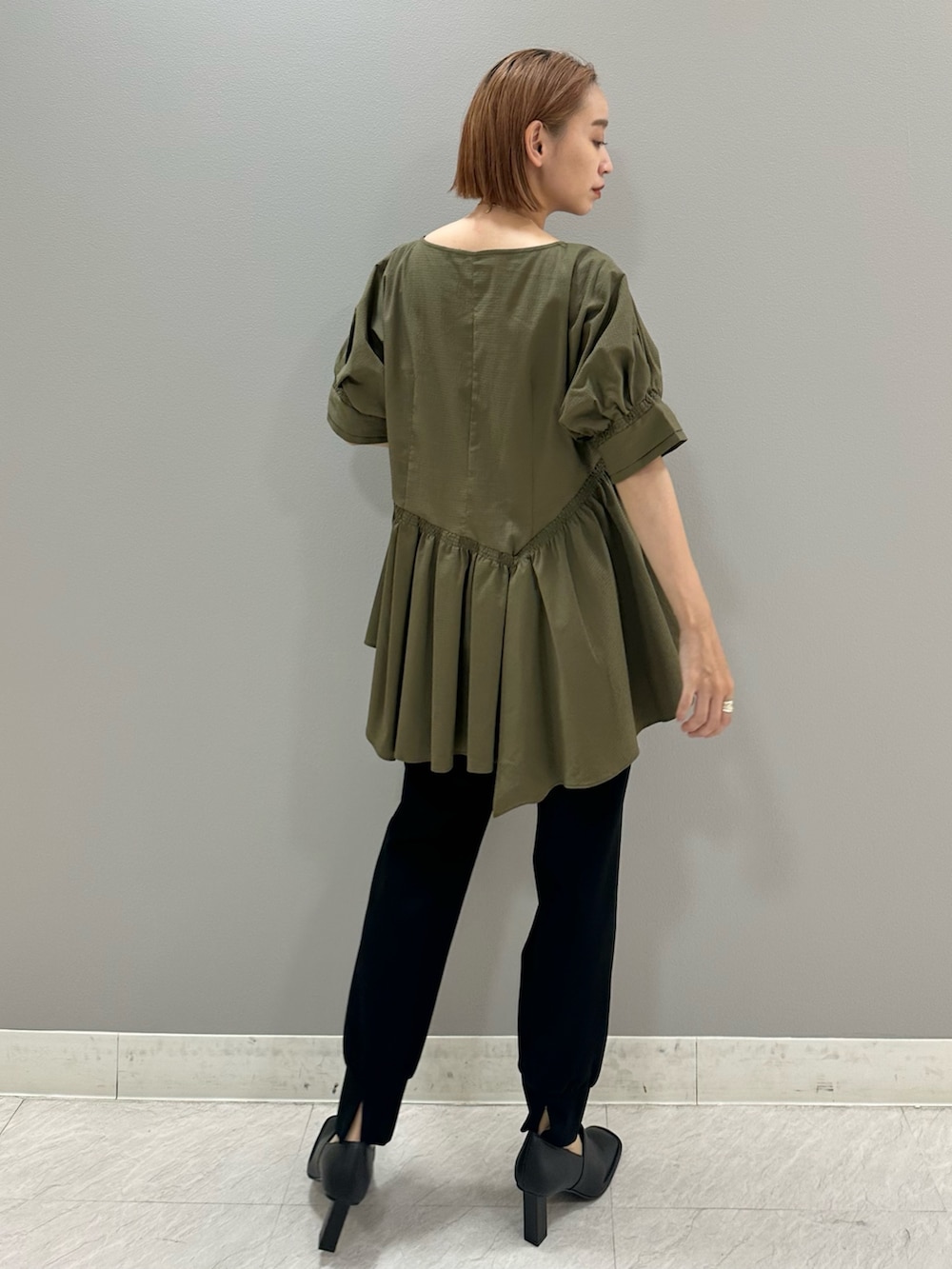 グリーン系のシャツ/ブラウス、ブラック系のスラックス、ブラック系のパンプスを着用したレディースの夏コーディネートの2枚目の写真