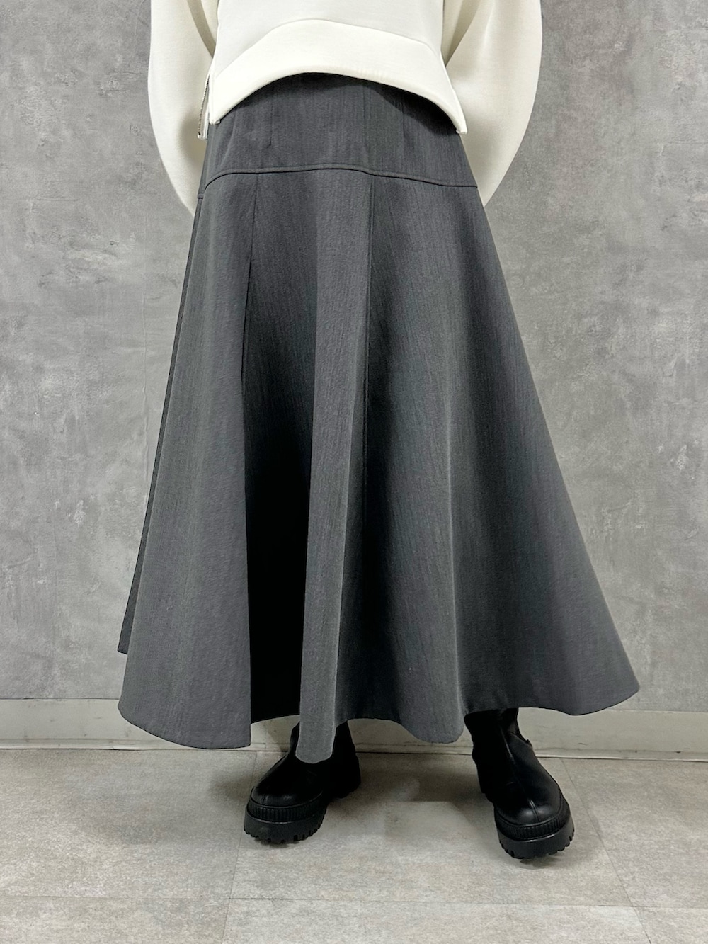 ホワイト系のTシャツ/カットソー、グレー系のスカートを着用したレディースの秋コーディネートの9枚目の写真