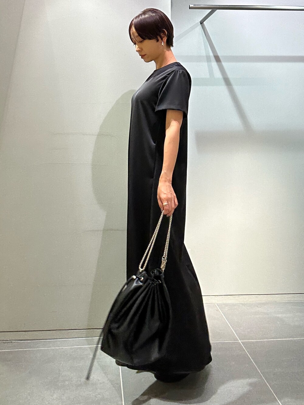 ブラック系のワンピース、ブラック系のサンダル、ブラック系のショルダーバッグを着用したレディースの夏コーディネートの2枚目の写真