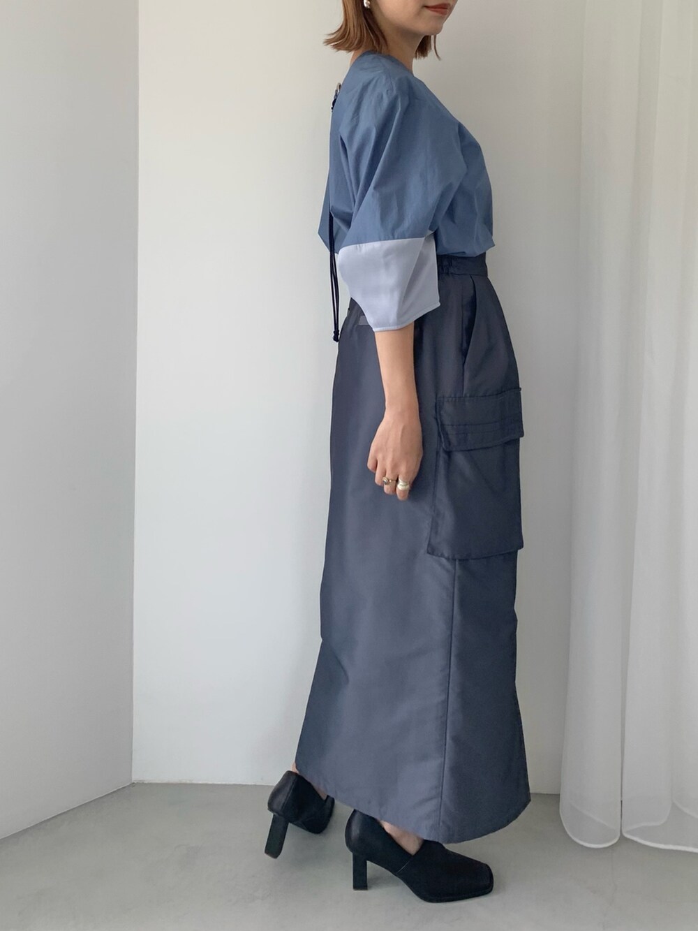 ブラック系のパンプス、ブルー系のスカート、ブルー系のシャツ/ブラウスを着用したレディースの春コーディネートの3枚目の写真