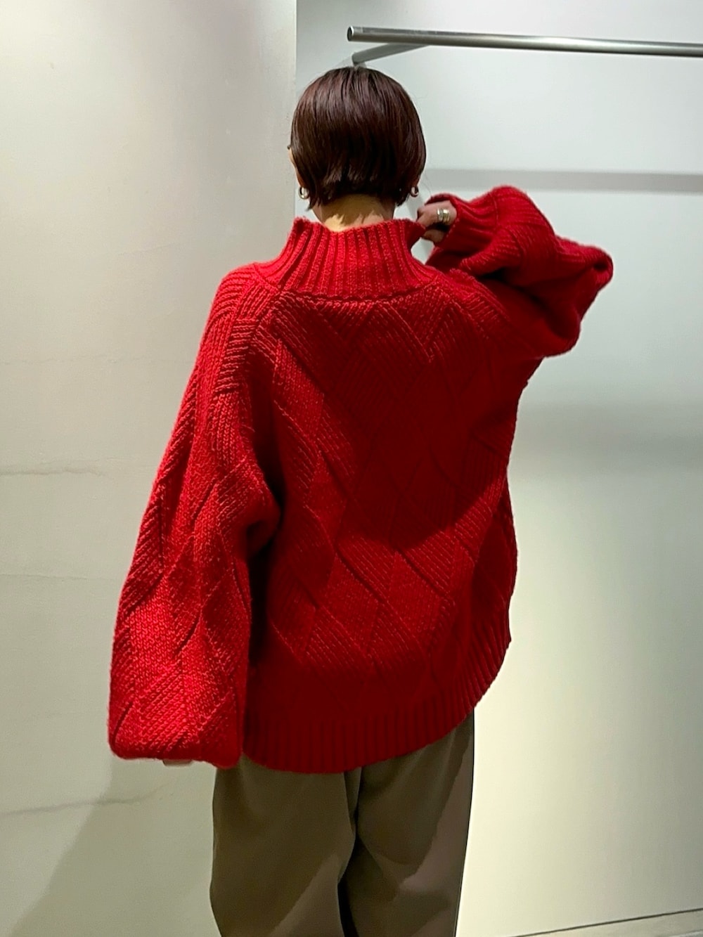 レッド系のニット/セーター、ブラウン系のその他パンツ、シルバー系のブーツを着用したレディースの秋コーディネートの8枚目の写真