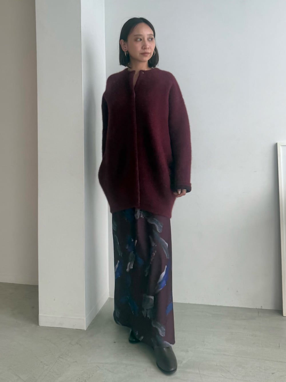 レッド系のスカート、レッド系のカーディガン/ボレロ、ブラック系のブーツを着用したレディースの夏コーディネートの2枚目の写真