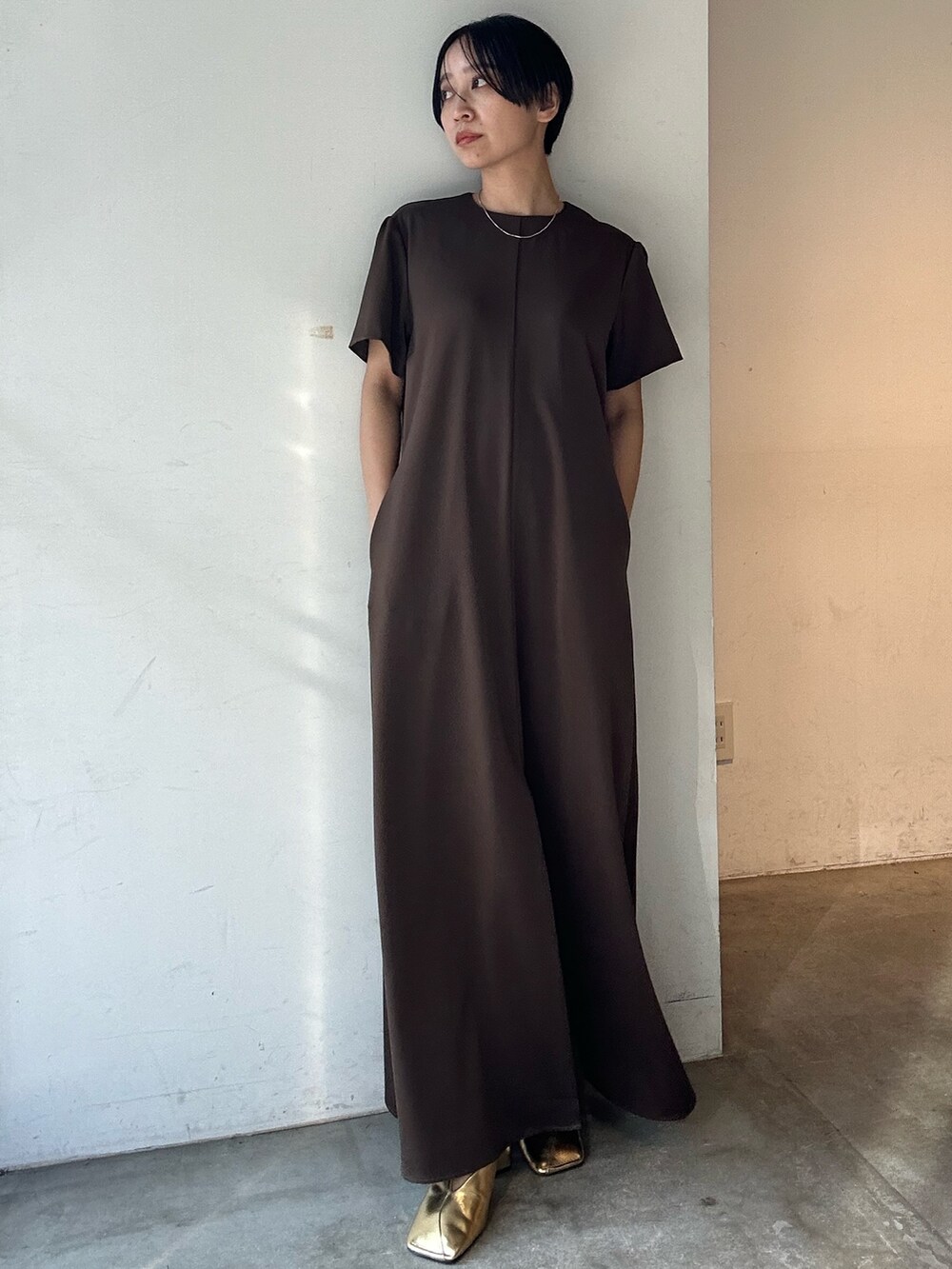 ブラウン系のワンピース、ゴールド系のパンプスを着用したレディースの春コーディネートの3枚目の写真