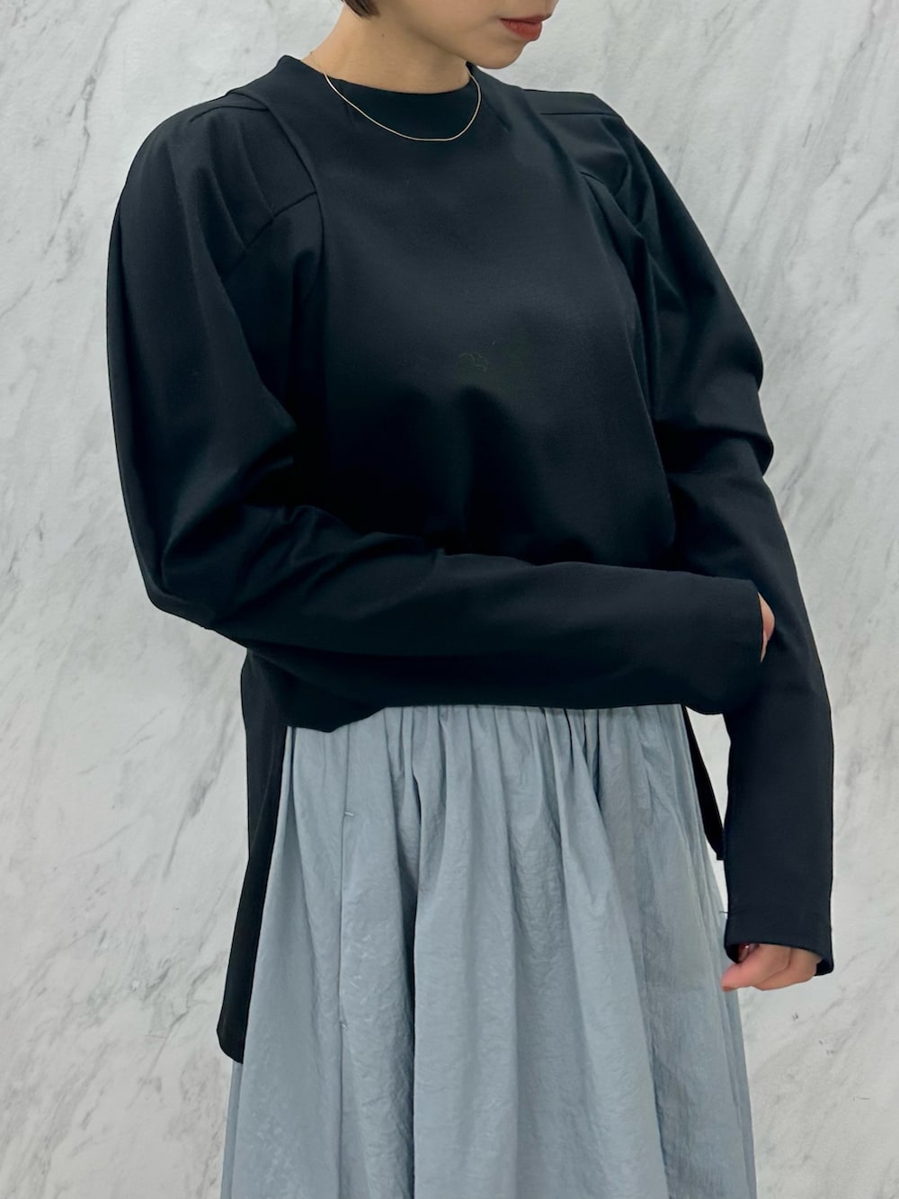 ブルー系のスカート、ブラック系のTシャツ/カットソー、ブラック系のブーツを着用したレディースの秋コーディネートの5枚目の写真