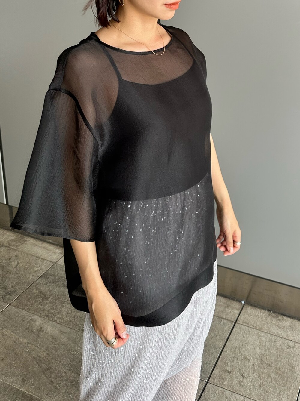 ブラック系のシャツ/ブラウス、シルバー系のスカートを着用したレディースの夏コーディネートの4枚目の写真