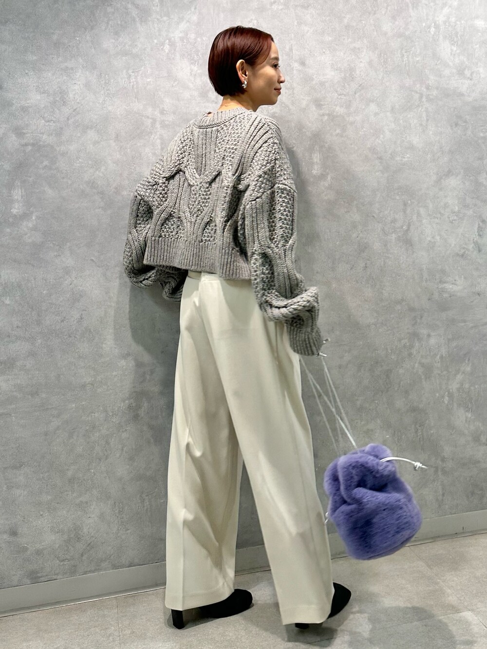 グレー系のニット/セーター、ホワイト系のその他パンツ、ブラック系のブーツを着用したレディースの秋コーディネートの2枚目の写真