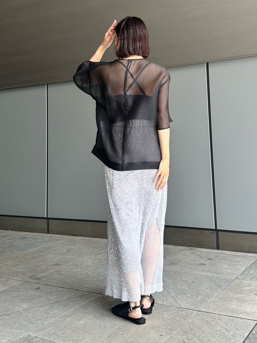 ブラック系のシャツ/ブラウス、シルバー系のスカートを着用したレディースの夏コーディネートの3枚目の写真