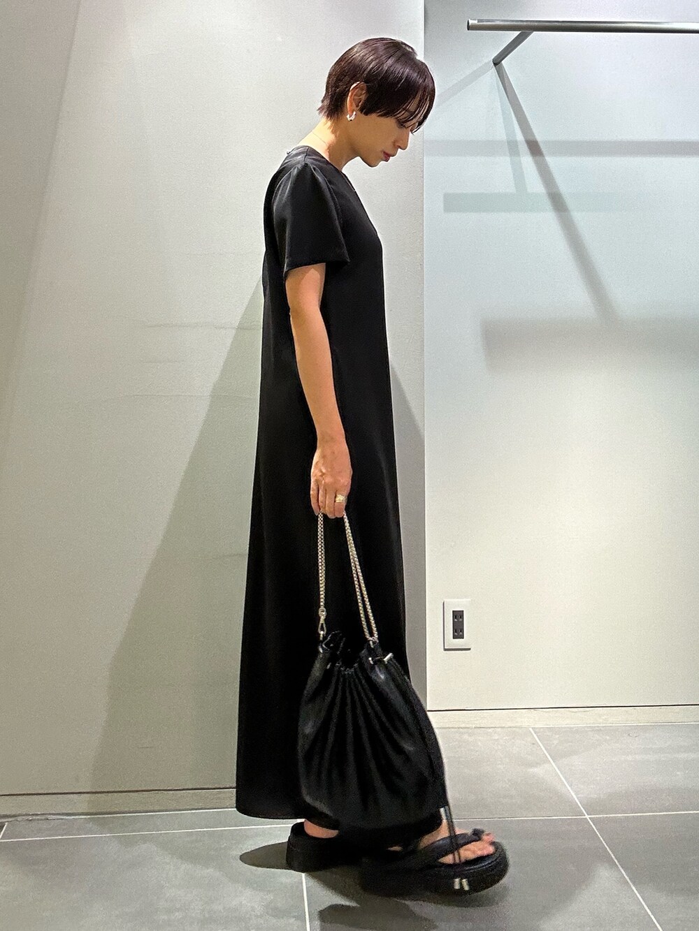 ブラック系のワンピース、ブラック系のサンダル、ブラック系のショルダーバッグを着用したレディースの夏コーディネートの3枚目の写真
