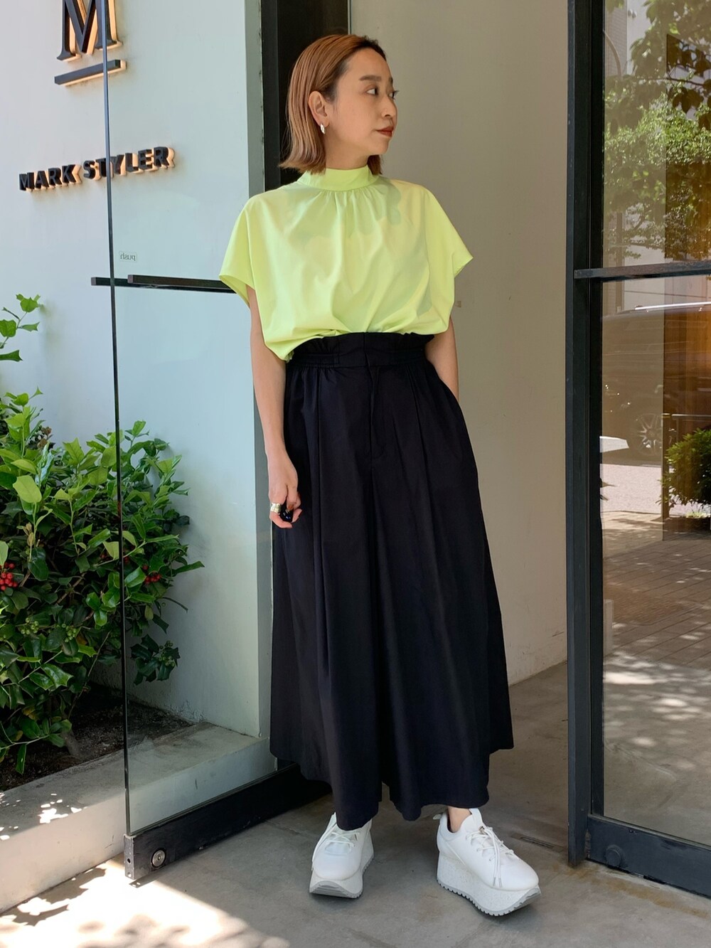 ブラック系のその他パンツ、ホワイト系のスニーカー、イエロー系のシャツ/ブラウスを着用したレディースの春コーディネートの2枚目の写真