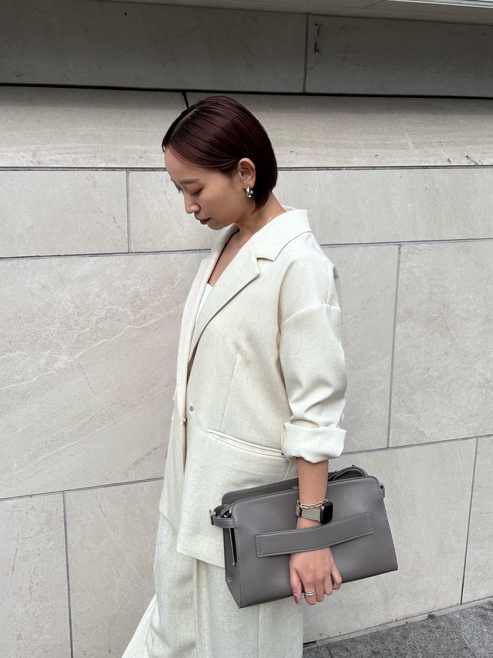 グレー系のハンドバッグ、ベージュ系のその他パンツ、シルバー系のサンダルを着用したレディースの春コーディネートの6枚目の写真