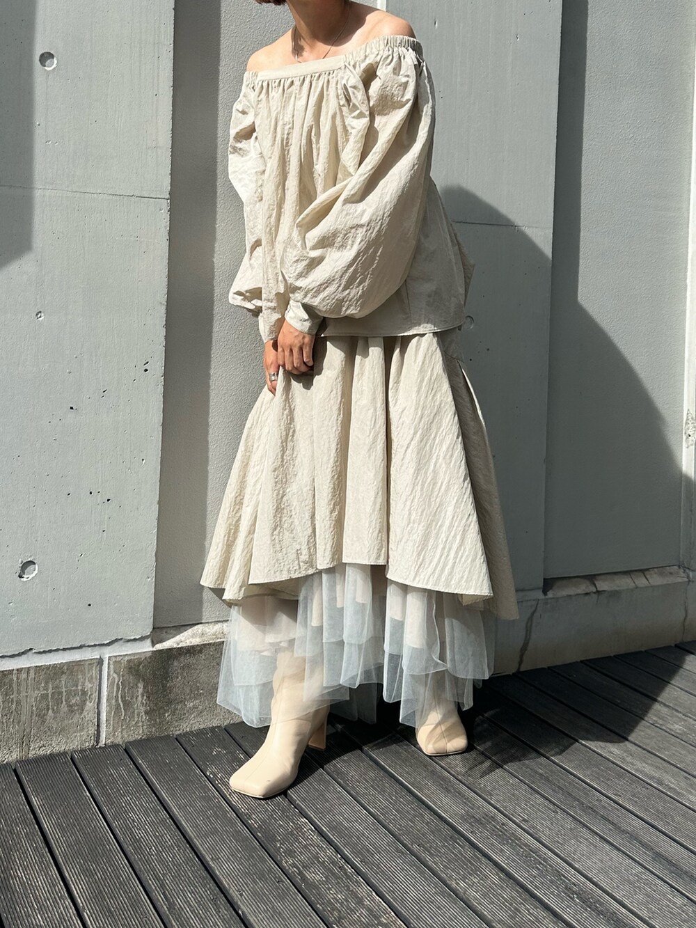 ベージュ系のブーツ、ベージュ系のスカート、ベージュ系のシャツ/ブラウスを着用したレディースの秋コーディネートの2枚目の写真