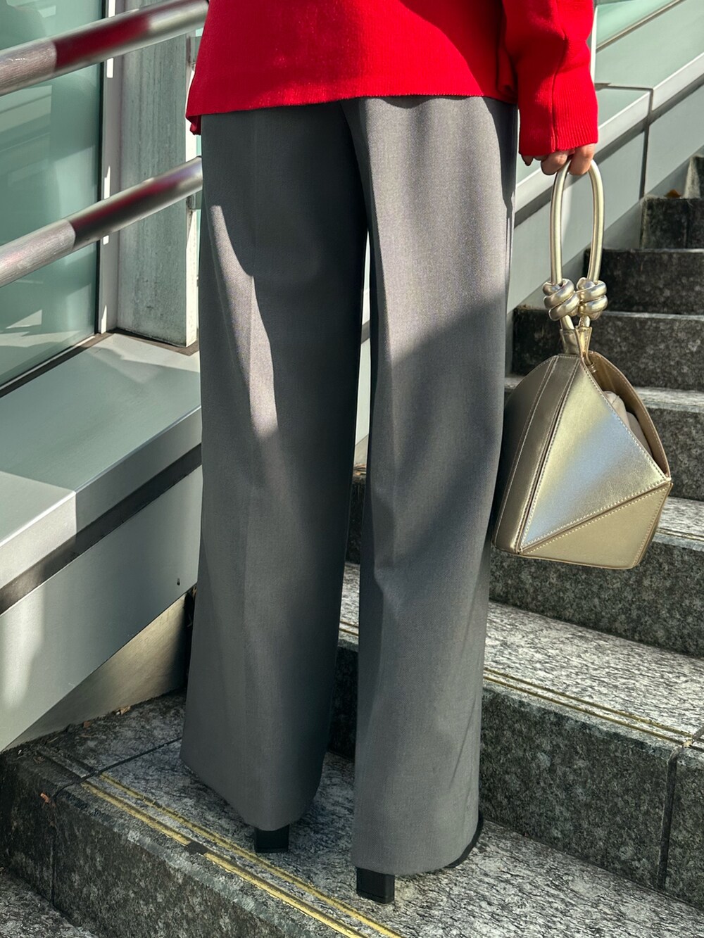 ブラック系のブーツ、グレー系のノーカラージャケット、レッド系のニット/セーターを着用したレディースの冬コーディネートの6枚目の写真