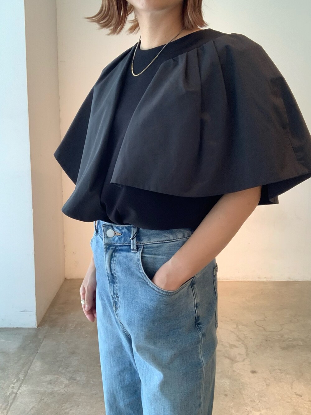ブラック系のTシャツ/カットソー、ブルー系のデニムパンツ、ブラック系のサンダルを着用したレディースの春コーディネートの6枚目の写真