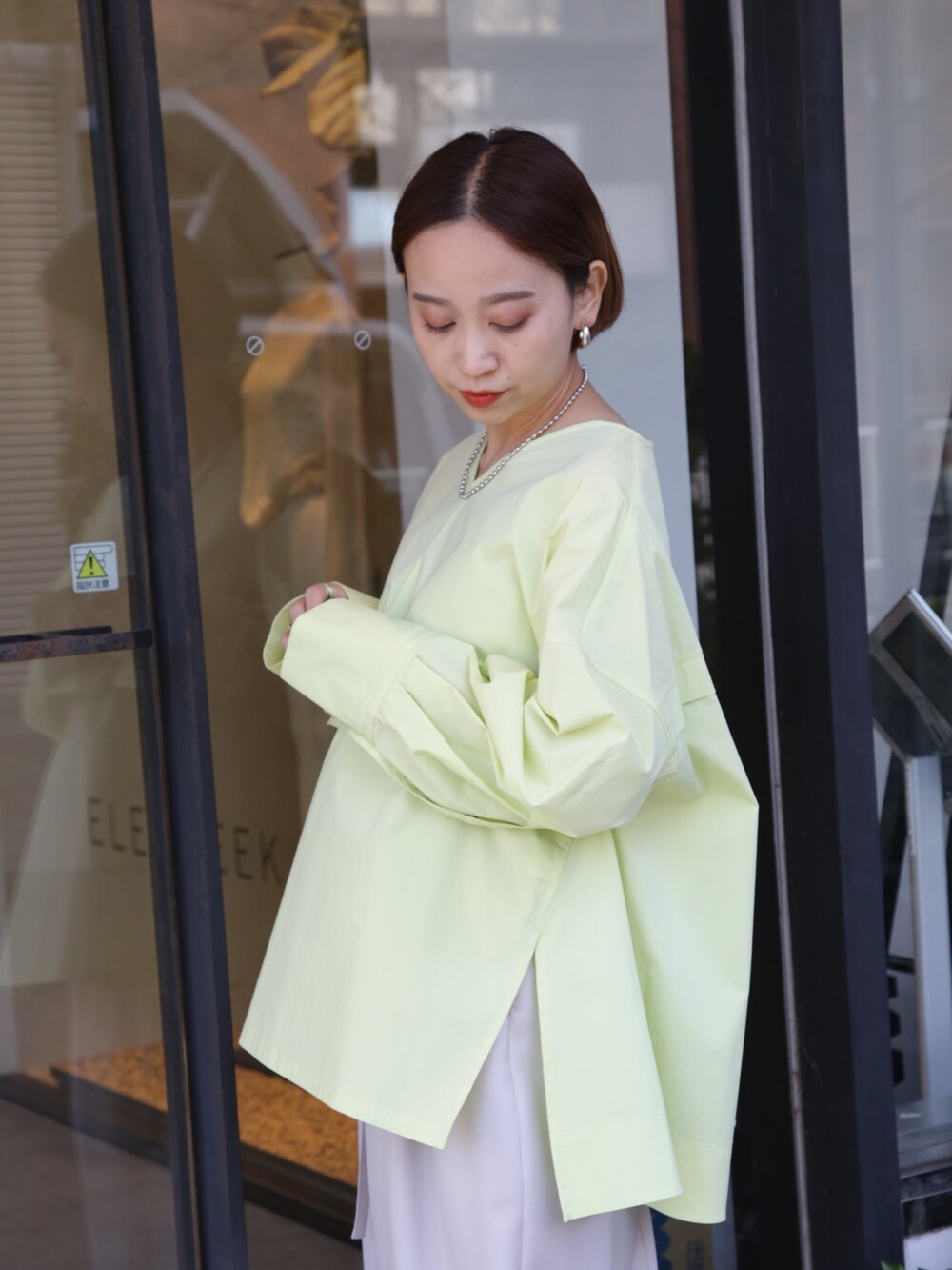 ベージュ系のスカート、ホワイト系のスニーカー、イエロー系のシャツ/ブラウスを着用したレディースの冬コーディネートの6枚目の写真