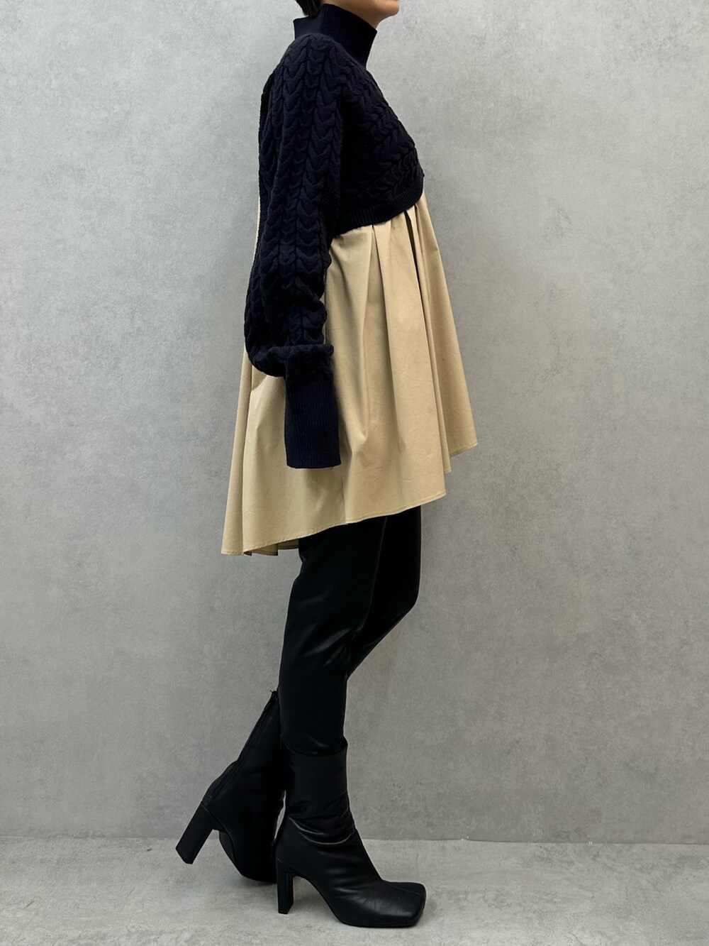 ブルー系のニット/セーター、ブラック系のその他パンツ、ブラック系のブーツを着用したレディースの秋コーディネートの2枚目の写真