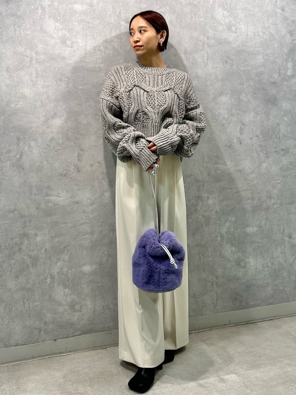 グレー系のニット/セーター、ホワイト系のその他パンツ、ブラック系のブーツを着用したレディースの秋コーディネートの3枚目の写真