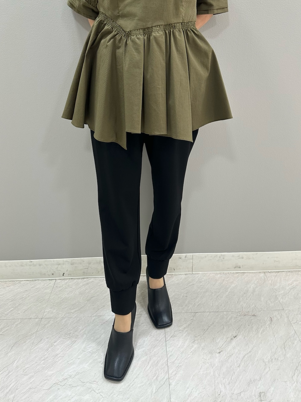 グリーン系のシャツ/ブラウス、ブラック系のスラックス、ブラック系のパンプスを着用したレディースの夏コーディネートの7枚目の写真