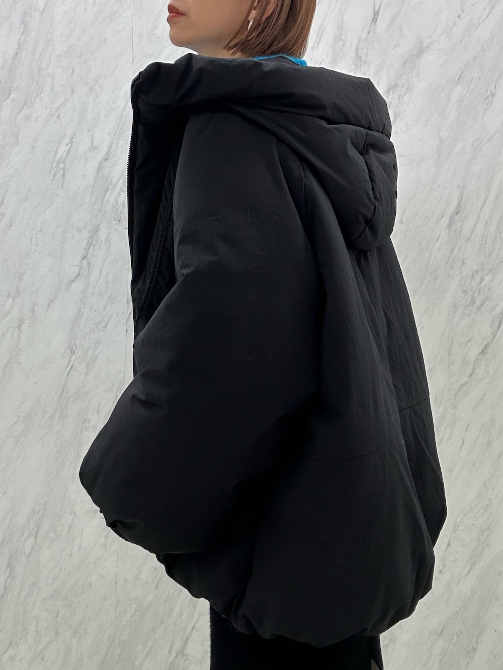 ブラック系のブーツ、ブラック系のスカート、ブラック系のダウンジャケット/コートを着用したレディースの秋コーディネートの4枚目の写真